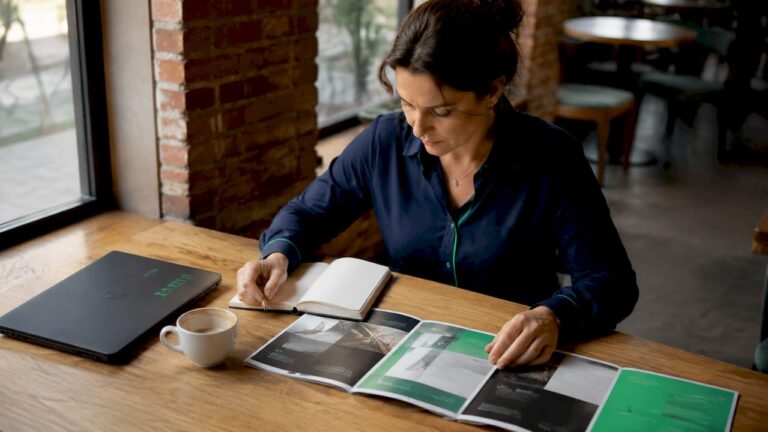 Une personne en train de comparer des brochures présentant un site vitrine et une boutique en ligne.