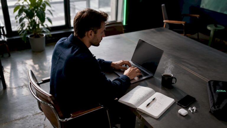 Un entrepreneur travaille seul sur son ordinateur portable, installé dans son bureau.