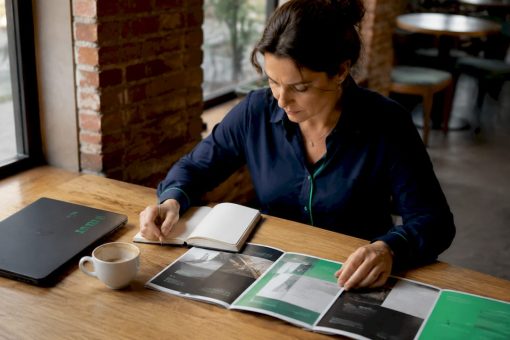Une personne en train de comparer des brochures présentant un site vitrine et une boutique en ligne.