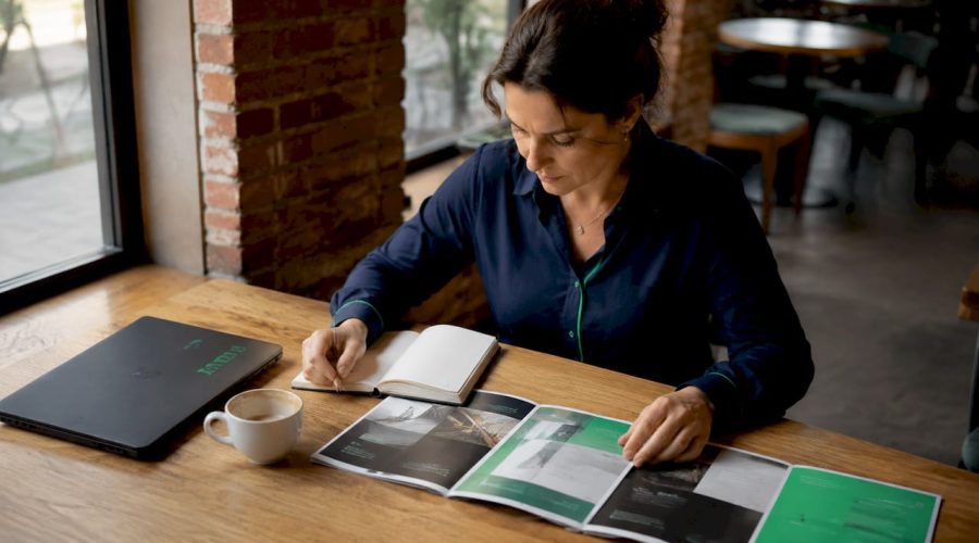 Une personne en train de comparer des brochures présentant un site vitrine et une boutique en ligne.