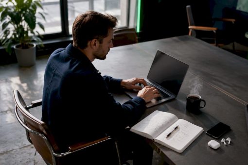 Un entrepreneur travaille seul sur son ordinateur portable, installé dans son bureau.