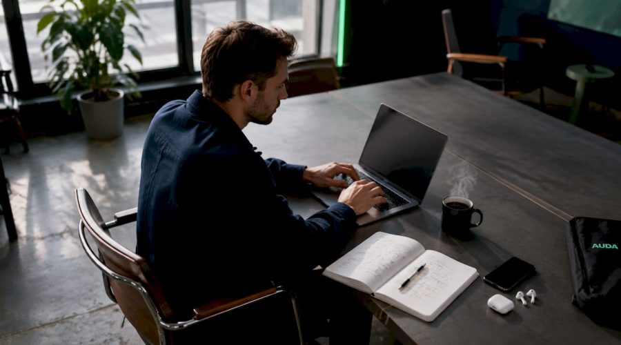 Un entrepreneur travaille seul sur son ordinateur portable, installé dans son bureau.